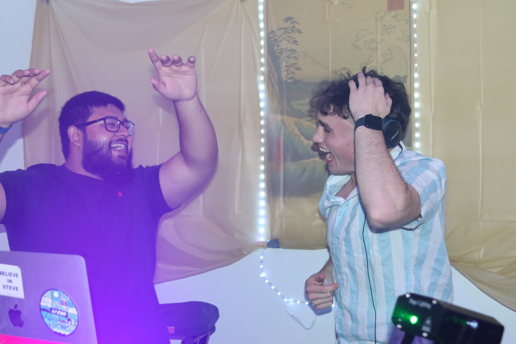 Celebrating together behind the DJ booth